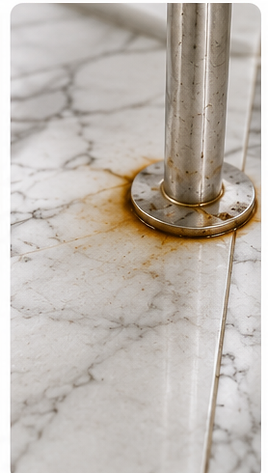 Circular rust mark around a metal fitting on marble